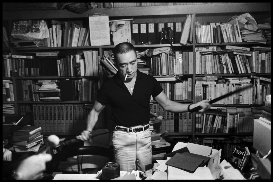 Yukio Mishima with books and sword